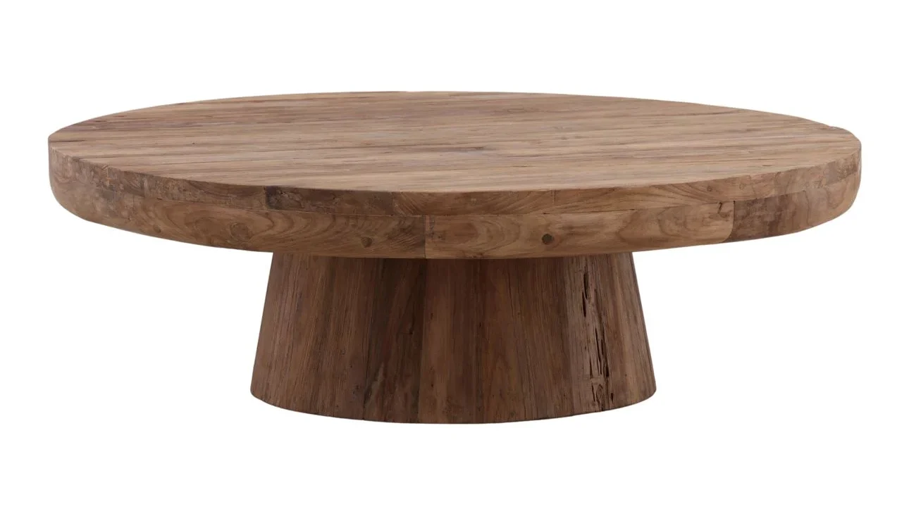 Round reclaimed teak wood coffee table with natural finish and pedestal base, showcasing rustic grain and organic texture, three quarter view