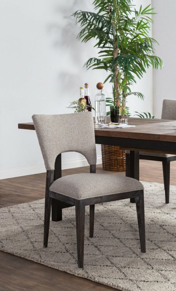 grey upholstered dining chair with black wood frame in setting