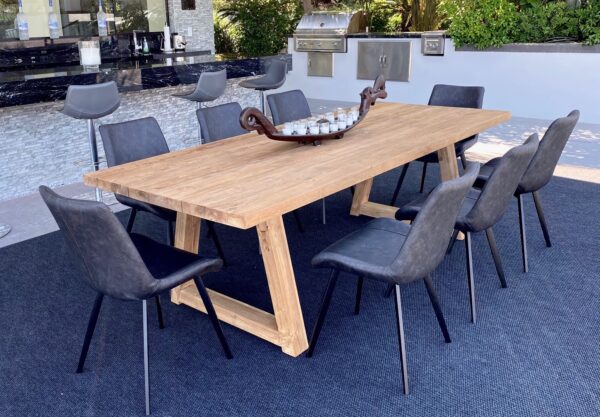 Large teak dining table shown in patio setting