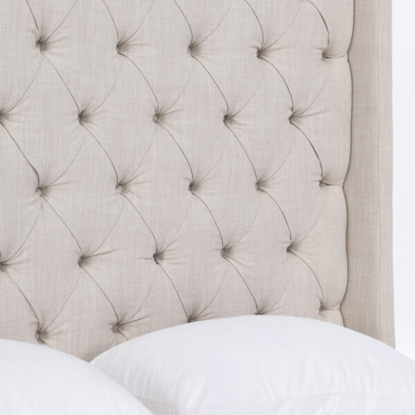 Light grey upholstered tufted queen size bed, headboard detail