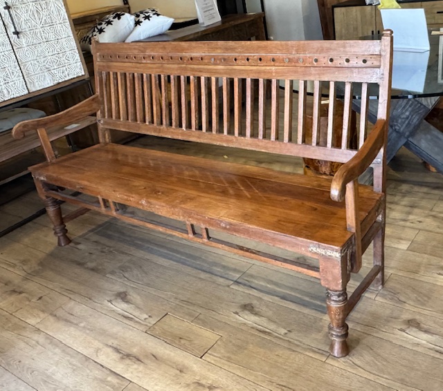 Antique Indonesian teak bench made from reclaimed solid wood with natural grain, warm patina, and handcrafted detailing. Three quarter view right