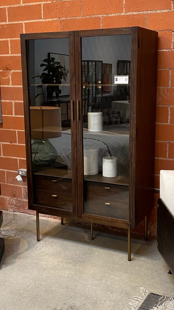 Dark wood tall cabinet with glass doors and brass color iron legs