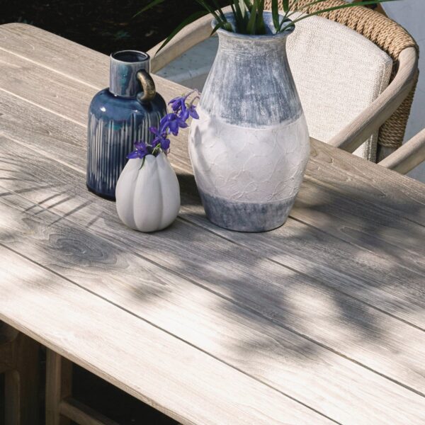 Counter high grey teak table for outdoor, with vases on top