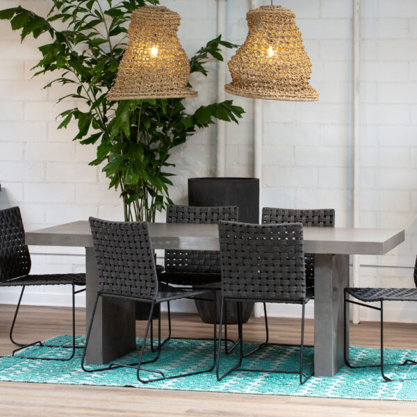 Light concrete dining table for outdoor use, shown in dining room setting.