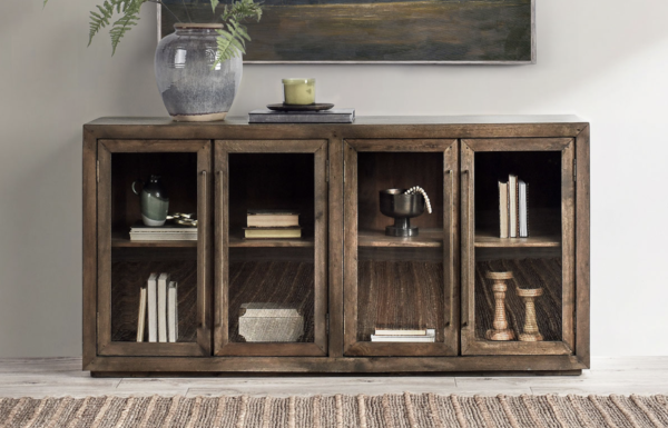 4 door glass cabinet in dark brown with interior shelf, in a setting