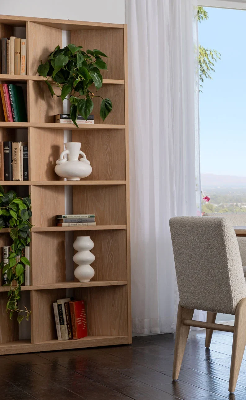 The Carpenter Bookcase is crafted from Oak wood and Oak Veneer, modern sophisticated bookcase with 5 shelves and 3 vertical running boards in diagonal as well as end board, staged view