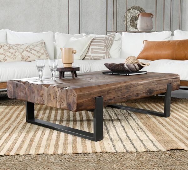 Rustic style coffee table with reclaimed wood top and iron base, shown in a living room