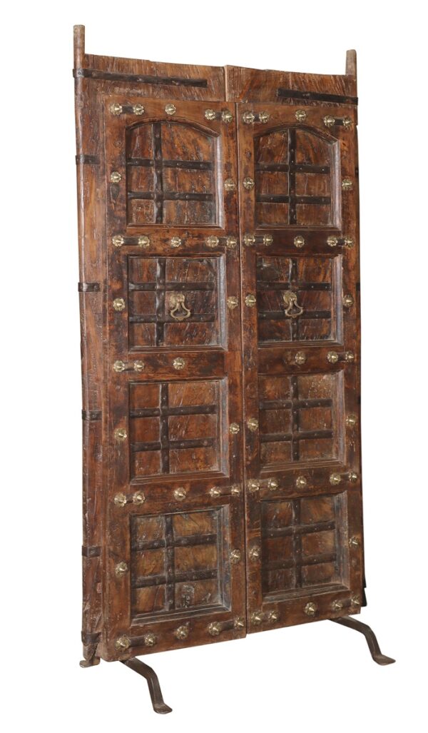 Antique set of doors with metal flowers set on iron stand