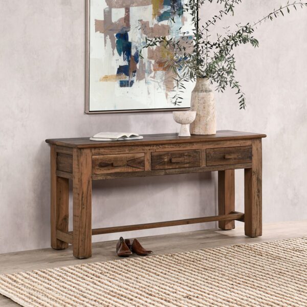 Reclaimed rustic wood console table with drawers, seen in home setting