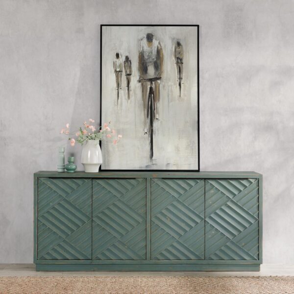 Teal color media cabinet with textured doors, interior shelves and cable holes, seen in a room